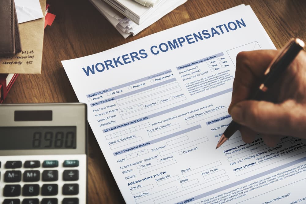 A man is filling out the Worker's Compensation Form